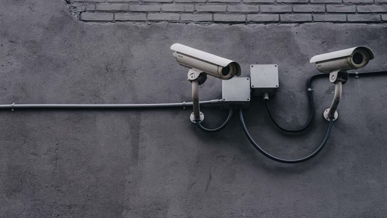 Two security cameras on a grey wall